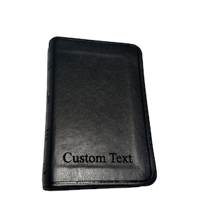 May include: A black leather journal with the text "Custom Text" embossed on the front cover.