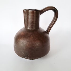 Puede incluir: Un juego de tres tazas de cerámica con un acabado moteado y mate. Las tazas son de color crema, gris claro y gris oscuro. Cada taza tiene un diseño simple y minimalista y un asa redondeada.