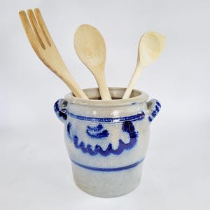 Könnte beinhalten: Ein Set aus drei Keramikbechern mit gesprenkelter, matter Oberfläche. Die Becher sind in Creme-, Hellgrau- und Dunkelgrautönen gehalten. Jeder Becher hat ein schlichtes, minimalistisches Design.