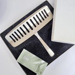 May include: A stainless steel fish serving set, including a slotted spatula and a small serving utensil, presented in a black box. A small card with text is also included. The set is designed for serving fish and other delicate foods.