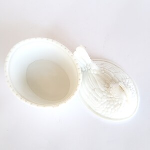 May include: White ceramic chicken-shaped dish with a lid. The lid is detailed with a raised design of feathers. The dish is empty.