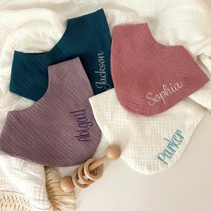May include: Four personalized baby bibs in different colors, with the names Abigail, Jackson, Sophia, and Parker embroidered on them. The bibs are made of soft, absorbent fabric and are perfect for keeping baby's clothes clean.