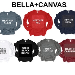 May include: A set of eight long-sleeved shirts in various colours and styles, including heather slate, heather red, heather navy, solid white blend, solid black blend, deep heather, and heather cardinal. The shirts are all Bella + Canvas brand.