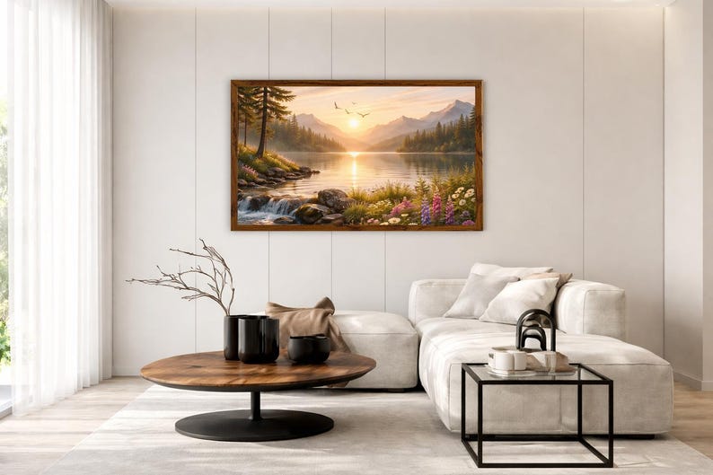 May include: A rectangular landscape painting in a dark wood frame depicting a serene mountain lake at sunset. The scene features a calm body of water reflecting the golden sun, surrounded by pine trees, rocky shores, and colorful wildflowers.