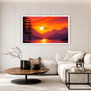May include: A rectangular wall art print featuring a vibrant sunset over a mountain lake. The scene displays deep purple mountain silhouettes, a bright orange and yellow sky, a calm reflective lake, and dark pine trees on the left with birds.