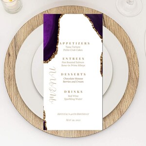 May include: A purple and gold agate-style menu with the text "MENU" written in cursive. The menu lists appetizers, entrees, desserts, and drinks for Krystal's 40th birthday on May 29, 2022.