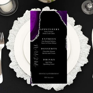 May include: A black and purple menu card with silver glitter accents. The menu lists appetizers, entrees, desserts, and drinks. The text at the bottom reads "Krystal's 40th Birthday May 29, 2022".