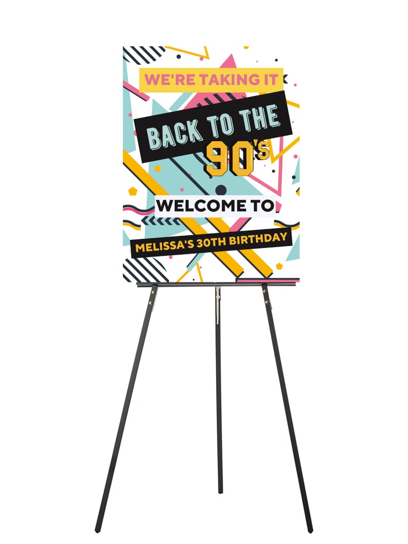 May include: A white poster with a colorful geometric design. The poster says "We're taking it back to the 90's. Welcome to Melissa's 30th Birthday". The poster is on a black easel.
