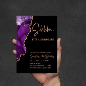 K&ouml;nnte beinhalten: Schwarze Geburtstagseinladung mit lila und goldenen Akzenten. Die Einladung lautet "Shhh... IT'S A SURPRISE" und enth&auml;lt Details f&uuml;r Shaylas 30. Geburtstag.