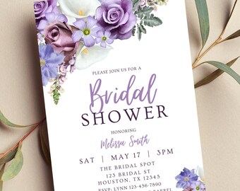May include: A white invitation card for a bridal shower, featuring a floral arrangement of purple roses, calla lilies, and other flowers. The text reads "Bridal Shower" and includes event details, such as the date, time, and location.