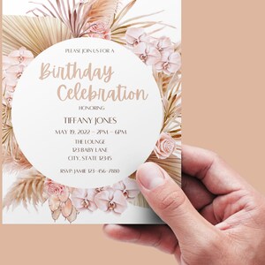 Pode incluir: Um convite branco com um design floral rosa e bege. O texto diz "Por favor, junte-se a n&oacute;s para uma celebra&ccedil;&atilde;o de anivers&aacute;rio em homenagem a Tiffany Jones, 19 de maio de 2022 - 14h00 - 18h00, The Lounge, 123 Baby Lane, City, State 12345, RSVP: Jamie 123-456-7880".