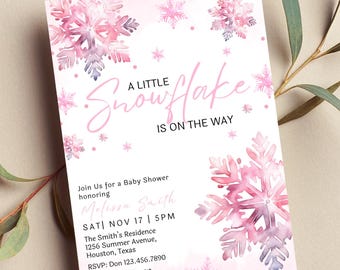 Pode incluir: Um convite de chá de bebê rosa e branco com um design de floco de neve. O texto diz "A Little Snowflake is on the Way". O convite inclui a data, a hora e o local do chá de bebê. Também inclui informações de RSVP.