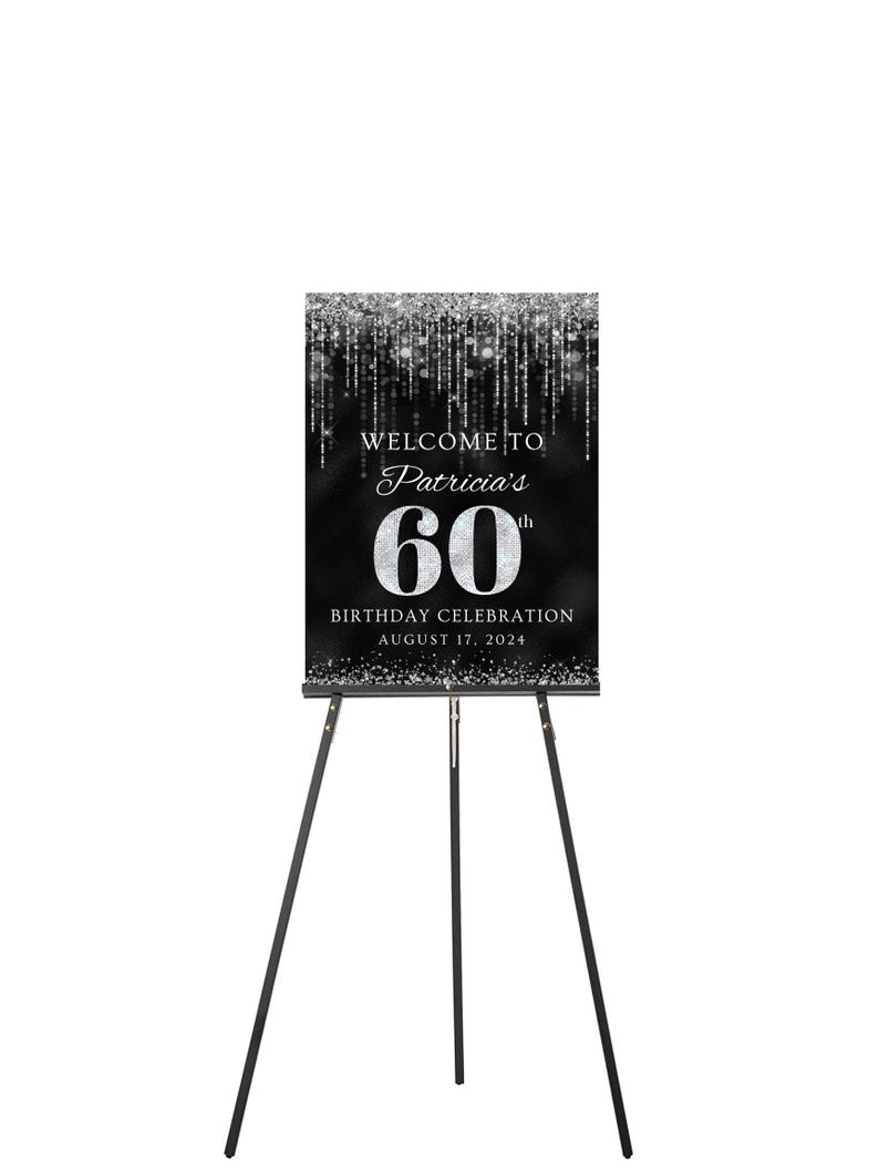May include: Black and silver welcome sign with a silver glitter background. The sign says "Welcome to Patricia's 60th Birthday Celebration August 17, 2024". The sign is on a black easel.