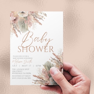 May include: A baby shower invitation with a floral design in shades of beige, brown, and pink. The text reads "Baby Shower" in a cursive font. The invitation includes the name "Melissa Smith", the date "Sat May 17", the time "6PM", the location "The Lounge Spot", the address "1256 Street, Riverdale, GA 30296", and the RSVP information "RSVP: Lynn 123-456-7890".