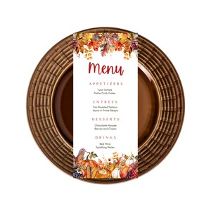 Pu&ograve; includere: Un piatto marrone con un motivo intrecciato attorno al bordo. Un menu con tema autunnale &egrave; posizionato sopra il piatto. Il menu presenta un'illustrazione ad acquerello di foglie autunnali e zucche. Il menu elenca antipasti, piatti principali, dessert e bevande.