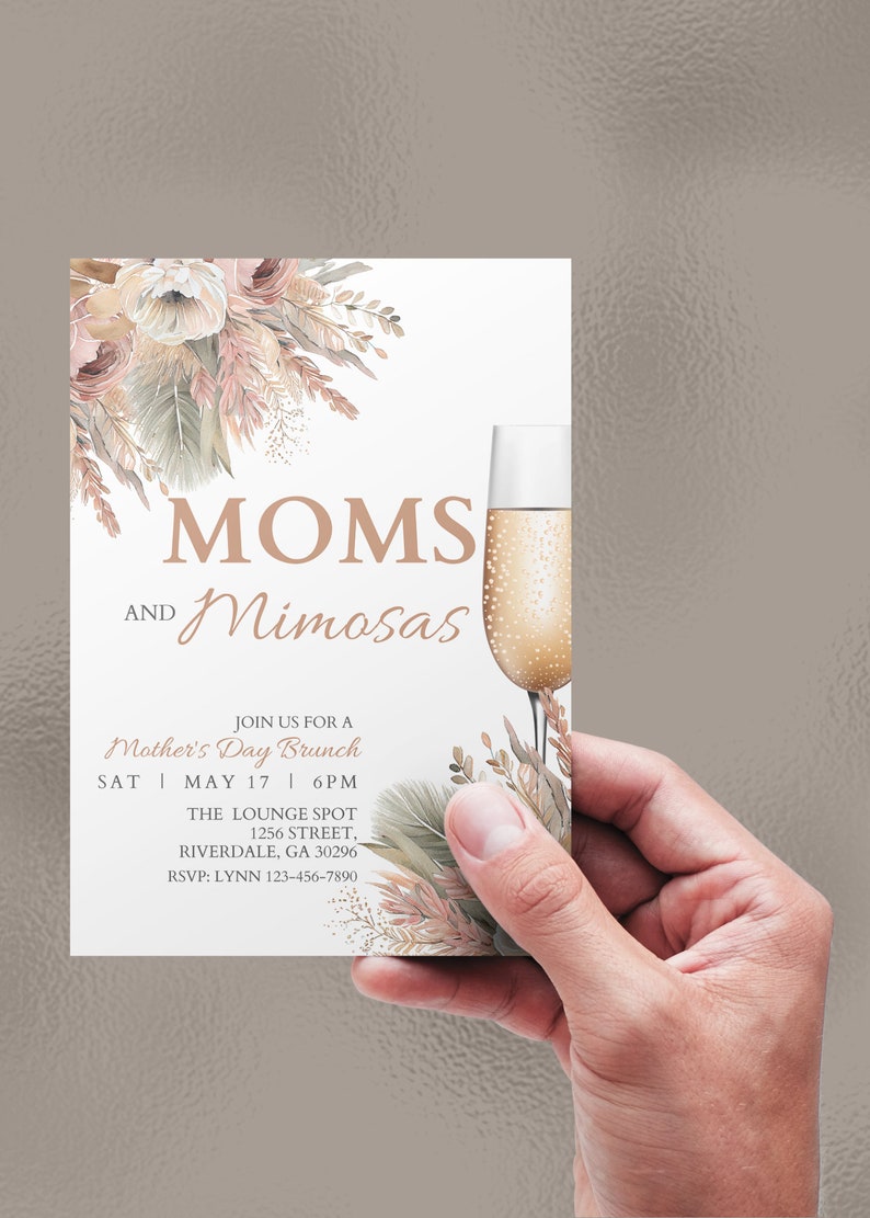 May include: A white invitation card with a floral design in shades of pink, beige, and gold. The text reads "MOMS AND Mimosas" and includes details for a Mother's Day brunch.