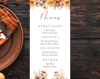 Könnte beinhalten: Ein Herbst-Menü mit einer Aquarell-Illustration von Kürbissen und Blumen. Die Speisekarte listet Vorspeisen, Hauptgerichte, Desserts und Getränke auf. Der Text lautet: "Theny", "Vorspeisen", "Thunfisch-Tatar", "Kleine Krabbenkuchen", "Hauptgerichte", "Gebratener Lachs", "Prime Rib mit Knochen", "Desserts", "Schokoladenmousse", "Beeren und Sahne", "Getränke", "Rotwein", "Sprudelwasser".
