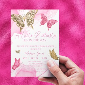 Op de afbeelding: Een witte babyshower-uitnodiging met roze en gouden glittervlinders. De tekst luidt "A Little Butterfly Is On The Way" en bevat de datum, tijd en locatie van het evenement. RSVP-informatie en registratiegegevens zijn ook inbegrepen.