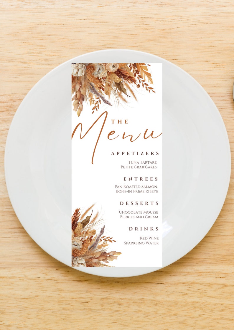 Op de afbeelding: Een witte menukaart met een bruin bloemenontwerp aan de boven- en onderkant. De tekst "The Menu" is geschreven in bruin cursief schrift. Het menu bevat voorgerechten, hoofdgerechten, desserts en dranken.