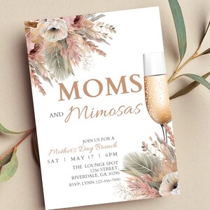 May include: Invitation to a Mother's Day brunch with the text "MOMS AND Mimosas" in brown lettering. The invitation features a floral design with pink and beige flowers, green leaves, and gold accents. The text includes the date, time, and location of the event.