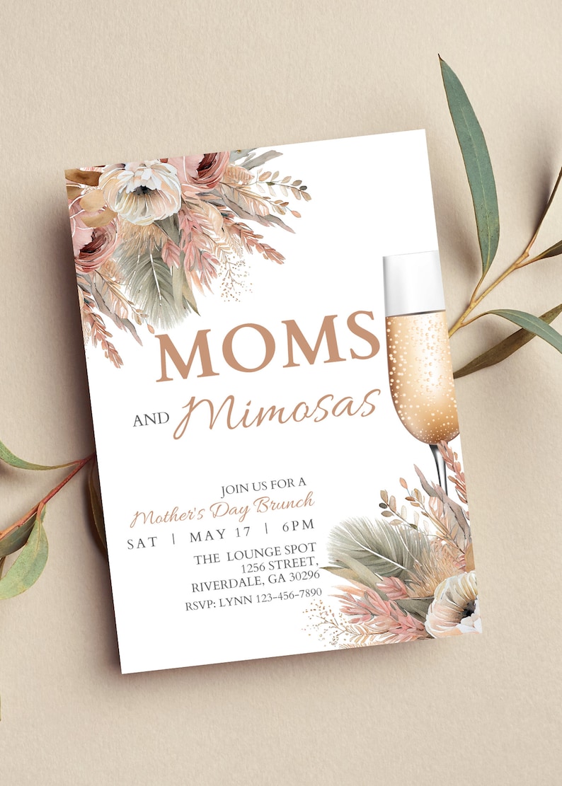 May include: Invitation to a Mother's Day brunch with the text "MOMS AND Mimosas" in brown lettering. The invitation features a floral design with pink and beige flowers, green leaves, and gold accents. The text includes the date, time, and location of the event.