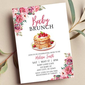 Puede incluir: Invitación para un Baby Brunch con detalles florales. La invitación presenta el texto "Baby Brunch" y los detalles del baby shower de Melissa Smith, incluyendo la fecha, hora y lugar. También incluye una ilustración de acuarela de panqueques con frambuesas.