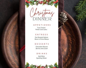 May include: A Christmas Dinner menu card with a festive design. The menu features appetizers, entrees, desserts, and drinks. The card is decorated with holly and floral accents, and is set on a wooden plate with a napkin and silverware.