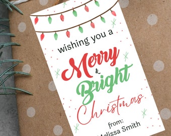 May include: White gift tag with a string attached. The tag has a red and green watercolor illustration of Christmas lights. The text reads "Wishing you a Merry & Bright Christmas from: Melissa Smith".