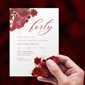 May include: A white invitation card with a red floral design and gold accents. The text on the card reads "forty" and includes details for a birthday celebration honoring Destinee Smith. The event is scheduled for Saturday, August 17th at 3 PM at Fred & Max Eatery, 1256 Summer Avenue, Houston, Texas. The RSVP information is provided with a phone number.