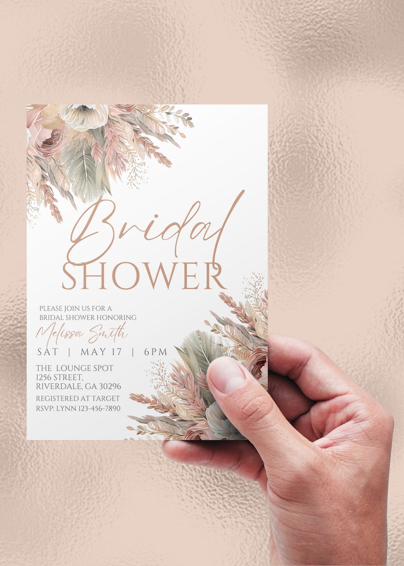 May include: A white bridal shower invitation with a floral design in shades of pink, beige, and green. The text reads "Bridal Shower" in a cursive font, followed by "Please join us for a bridal shower honoring Melissa Smith" and the date and time of the event. The invitation also includes the location, "The Lounge Spot, 1256 Street, Riverdale, GA 30296", and the registry information, "Registered at Target". The RSVP information is "RSVP: Lynn 123-456-7890".