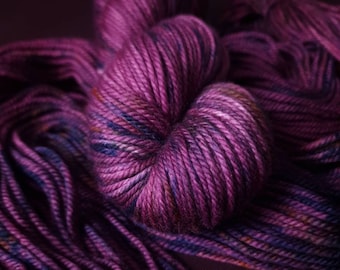May include: A skein of purple yarn with blue and brown flecks. The yarn is soft and fluffy, and it would be perfect for knitting or crocheting.