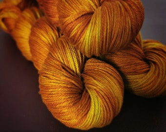 Könnte beinhalten: Nahaufnahme einer Garnrolle in Orange- und Gelbtönen. Das Garn ist weich und flauschig und perfekt zum Stricken oder Häkeln.