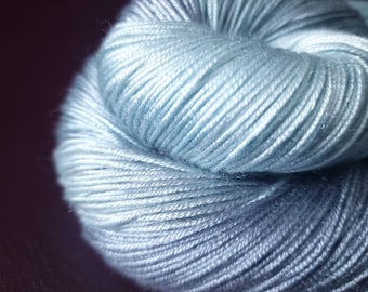 Könnte beinhalten: Eine Knäuel hellblaues Garn mit einem Farbverlauf von einem helleren Blau zu einem dunkleren Blau.
