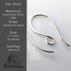 May include: Close-up of Argentium silver shepherd's hook ear wires. The ear wires are approximately 1 inch in length and 20 gauge. The text on the left side of the image reads "Ear Wires, Material: Argentium Silver 940, Style: Shepherds Hook, Size: ~1 Inch 20 Guage, Coating: Uncoated."