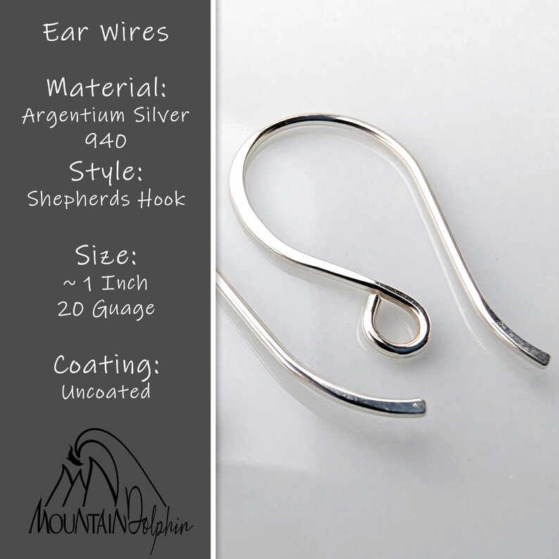 May include: Close-up of Argentium silver shepherd's hook ear wires. The ear wires are approximately 1 inch in length and 20 gauge. The text on the left side of the image reads "Ear Wires, Material: Argentium Silver 940, Style: Shepherds Hook, Size: ~1 Inch 20 Guage, Coating: Uncoated."