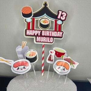 May include: A cake topper set featuring a red and gold pagoda, sushi, chopsticks, and a soy sauce bottle. The topper reads "Happy Birthday Murilo" and "13".