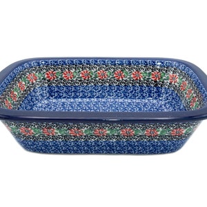 May include: A blue and white ceramic baking dish with a floral pattern in red and green. The dish has a square shape with rounded corners.