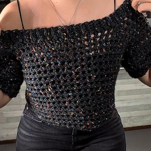 Close-up front view of the dark speckled mesh crochet top showing the openwork stitch pattern and neckline.