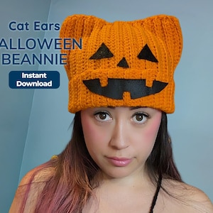 A person wearing a ribbed orange crochet cat ear beanie with black jack-o-lantern facial features and promotional text overlaid.