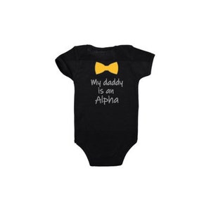 May include: Black baby onesie with a yellow bow tie and the text "My daddy is an Alpha" printed on the back.