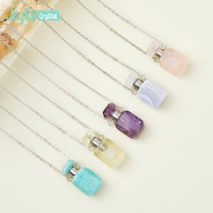 Pode incluir: Seis colares de corrente prateada com pingentes de garrafa de cristal. As garrafas são de vidro transparente e estão cheias de cristais de diferentes cores. Os cristais são ametista, quartzo transparente, ágata azul, quartzo rosa e amazonita.