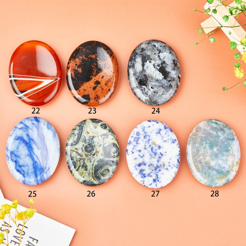 May include: Set of 7 oval-shaped polished stones with various patterns and colors, including blue, green, red, black, and white. The stones are numbered 22 through 28.
