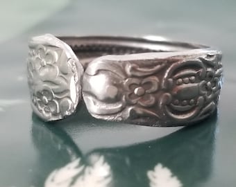 Op de afbeelding: Een zilveren ring gemaakt van een lepel met een bloemenmotief.