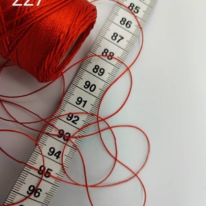 Puede incluir: Una bobina de hilo rojo con una cinta m&eacute;trica que muestra de 82 a 99 pulgadas. La bobina est&aacute; etiquetada con "227".
