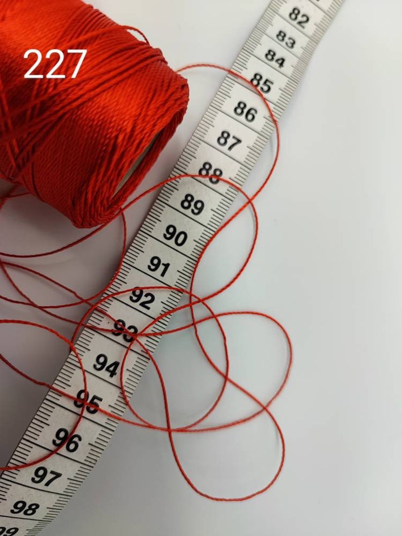 Puede incluir: Una bobina de hilo rojo con una cinta m&eacute;trica que muestra de 82 a 99 pulgadas. La bobina est&aacute; etiquetada con "227".