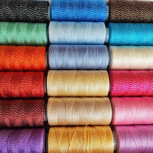 Può includere: Una collezione di 18 bobine di filo in vari colori, tra cui nero, blu, verde, arancione, rosso, oro, rosa, viola e bianco. Ogni bobina ha un effetto metallizzato.