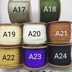 May include: Assortment of spools of waxed cord in various colors, including green, white, beige, yellow, purple, and black. Each spool is labeled with a letter and number, such as A17, A18, A19, A20, A21, A22, A23, and A24.  There are also seven small, smooth stones in various colors, including red, orange, brown, green, blue, purple, and white.