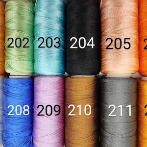 Puede incluir: Una colecci&oacute;n de 12 carretes de hilo en varios colores, incluyendo naranja, verde, azul, blanco, negro, marr&oacute;n, gris y amarillo. Los carretes est&aacute;n numerados del 201 al 212.