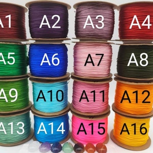 May include: A collection of 16 spools of waxed cord in various colors, labeled A1 through A16. The spools are arranged in four rows of four, with each row containing a different color.