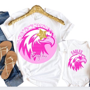 Águilas preppy rosas PNG con diseño digital de ojo de estrella Descarga de camisetas de sublimación Vasos DTF Mascota de escuela secundaria Universidad universitaria